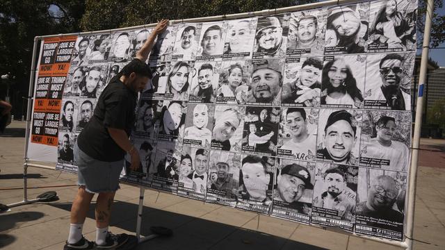 A volunteer sets up an art installation displaying names and faces of people who have been detained, deported, or sent to offshore camps during ICE raids in Southern California, at Olvera Street Plaza in Los Angeles, on Thursday, July 3, 2025. (AP Photo/Damian Dovarganes)