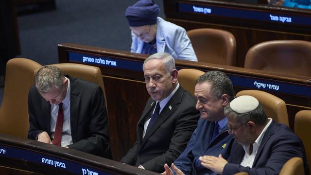 Israel's Prime Minister Benjamin Netanyahu, surrounded by ministers from the government attends a session of the Knesset, Israel's parliament, in Jerusalem, Monday, July 14, 2025. (AP Photo/Ohad Zwigenberg)