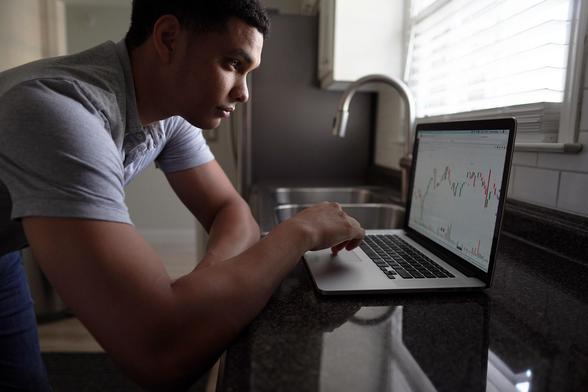 A man looks a chart on his laptop.