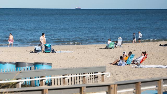 People relax at Rehoboth Beach, Del., on Wednesday, Aug. 27, 2025. (AP Photo/Mingson Lau)