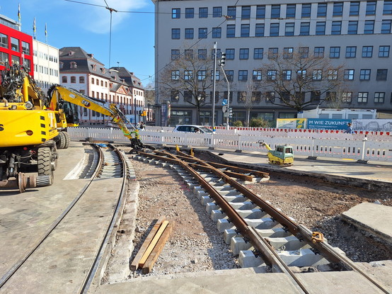 Foto der Straßenbahnbaustelle am Münsterplatz. Die Gleiskreuzung aus Richtung Schillerplatz in Richtung Alicenplatz ist bereits eingebaut.